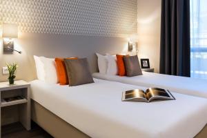 a hotel room with two beds and two lamps at Citadines Montmartre Paris in Paris