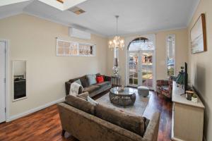 un soggiorno con un divano e un tavolo di Pembroke - CBD, Elegant & Character Filled Stay a Wagga Wagga Altre 24 foto