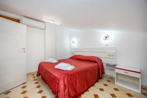 Un dormitorio con una cama roja con toallas. en Casa Artale Capo D'Orlando, en Capo dʼOrlando