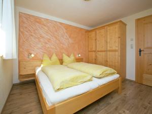 a bedroom with a bed with yellow pillows at Chalet in Hopfgarten in Hopfgarten im Brixental