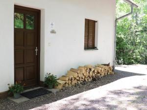 a building with a bunch of logs next to a door at Mountains Family Retreat in Rudník