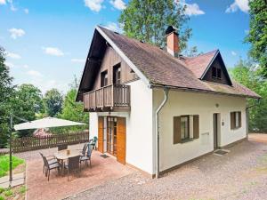 a small white house with a table and chairs at Mountains Family Retreat in Rudník