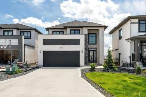 a large white house with a garage at Magnificent Stylish Escape in Bélanger
