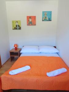 um quarto com uma grande cama laranja e 2 almofadas em Apartments Davor em Drage