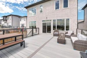 a large deck with furniture and a building at Magnificent Stylish Escape in Bélanger