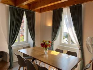 a dining room with a wooden table and two windows at Duplex avec vue lac et montagnes in Montreux