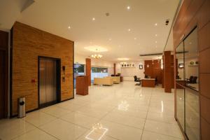 an office lobby with a brick wall and a lobby at Hotel Abaam Neil in Kumarakom
