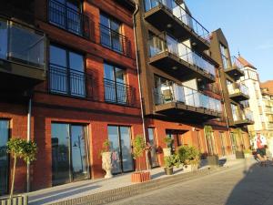 un bâtiment en briques avec des fenêtres et des plantes en pot dans une rue dans l'établissement Apartamenty De Soleil, à Ustka