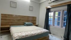 a bedroom with a bed and a window at LA Mili A Luxury Homestay in North Lakhimpur