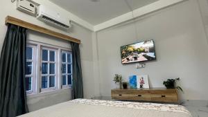 a bedroom with a bed and a tv on the wall at LA Mili A Luxury Homestay in North Lakhimpur
