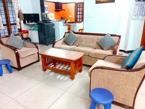 a living room with couches and chairs and a table at Helios Villa in Auroville