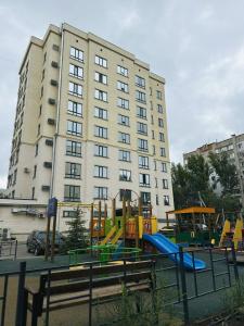 a playground in front of a large building at Family Comfort 97 in Uralsk
