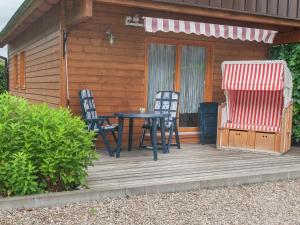 a wooden deck with two chairs and a table at Peaceful Stay in Gehren in Altenfeld