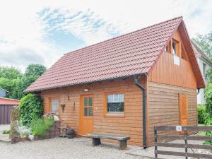 a small wooden cabin with a bench in front of it at Peaceful Stay in Gehren in Altenfeld