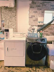 a laundry room with a washer and a brick wall at Daegu Dongseongro Gyeong`s Hostel in Daegu +68 photos