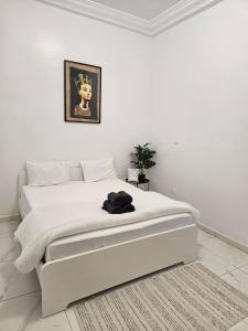 a white bedroom with a large white bed in a room at Résidence Jordan in Dakar