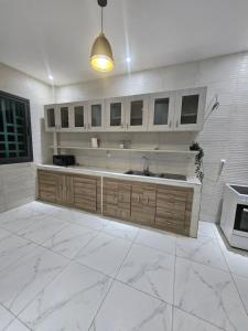 a kitchen with white marble floors and a sink at Résidence Jordan in Dakar