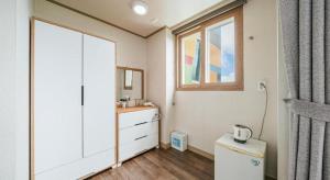 a bathroom with a white cabinet and a window at Orange Hotel Jeju in Seogwipo +212 photos