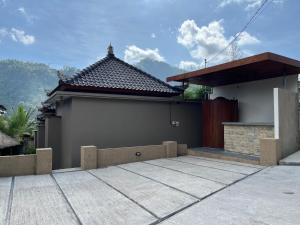 a house with a garage with a roof at The Banjar Homestay in Sidemen