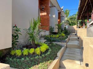 a garden with stairs leading to a building with plants at The Banjar Homestay in Sidemen