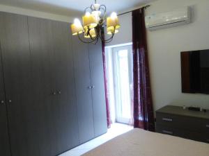 Schlafzimmer mit einem Bett, einem Fenster und einem Kronleuchter in der Unterkunft Arte Mare e Cultura in Pettineo