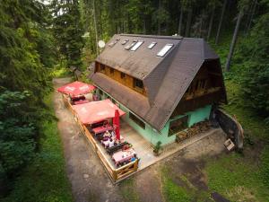 a small house with people sitting outside of it at Apartmány Jakub in Belá