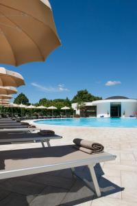 a row of lounge chairs next to a swimming pool at Hotel Salus Terme - Adults Only in Viterbo