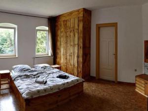 a bedroom with a large bed and two windows at Historische Villa in Sachsen in Großschirma