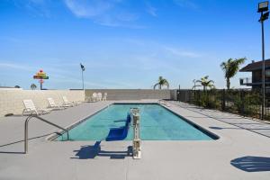 a swimming pool with lounge chairs and a swimming pool at Days Inn by Wyndham Lost Hills in Lost Hills