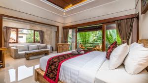 a bedroom with a large bed and a living room at Bendito Ubud in Ubud