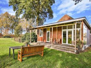 a wooden house with a bench in the yard at Holiday Home in Tripscompagnie near Nature in Tripscompagnie +28 photos