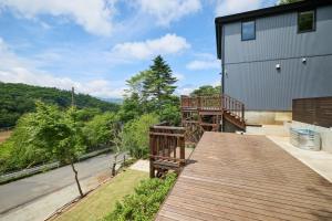 a wooden deck on the side of a house at COCO VILLA 山中湖 -Lake Yamanakako- in Yamanakako