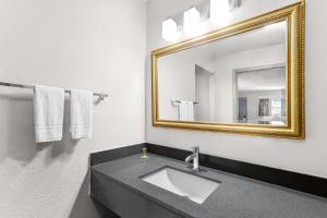 a bathroom with a sink and a mirror at Days Inn by Wyndham Huntington in Pea Ridge +32 photos