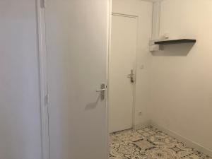 a bathroom with a door and a tile floor at L escapade cantalienne in Aurillac