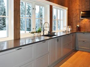 a kitchen with white cabinets and a sink and windows at 12 person holiday home in Fåvang in Favang