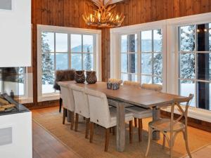 a dining room with a table and chairs and windows at 12 person holiday home in Fåvang in Favang