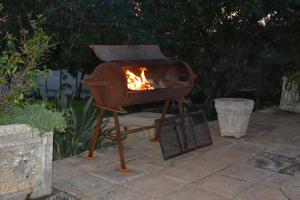 a grill with a fire in it on a patio at The Fever Tree Guest House in Hluhluwe