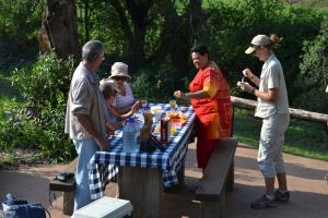 a group of people standing around a picnic table at The Fever Tree Guest House in Hluhluwe