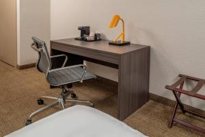 a desk with a chair and a lamp on it at Clarion Pointe Beckley in Beckley