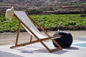 Una silla de playa con un sombrero encima en Vino Houses, en Oia