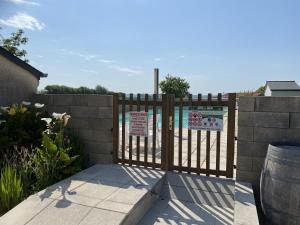 a wooden fence with a gate with signs on it at Gites des Sablons in Cherrueix
