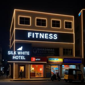 a building with a sign for a hotel at night at Silk White in Hyderabad