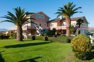 ein großes Haus mit Palmen im Hof in der Unterkunft Casa Marino Pensión ** in Villapedre