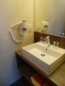 a bathroom with a white sink and a mirror at Hotel Kristoffel in Middelkerke