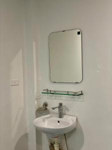 a bathroom with a sink and a mirror on the wall at Lotuz Hanoi Hostel - Ha Giang Loop Office in Hanoi