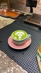 a cup of coffee on a pink plate on a table at Lotuz Hanoi Hostel - Ha Giang Loop Office in Hanoi +46 photos