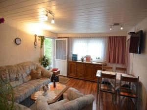 a living room with a couch and a table at Heatable Pool Retreat in Neuhaus am Rennweg +26 photos