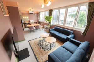 a living room with blue couches and a table at menow in Otaru