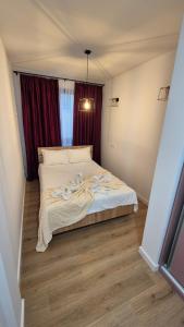 a large bed in a room with red curtains at Matei Rent Apartments - Premium Stays & Free Parking in Baia Mare