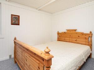 a bedroom with a wooden bed in a room at 4 person holiday home in Præstø in Præstø